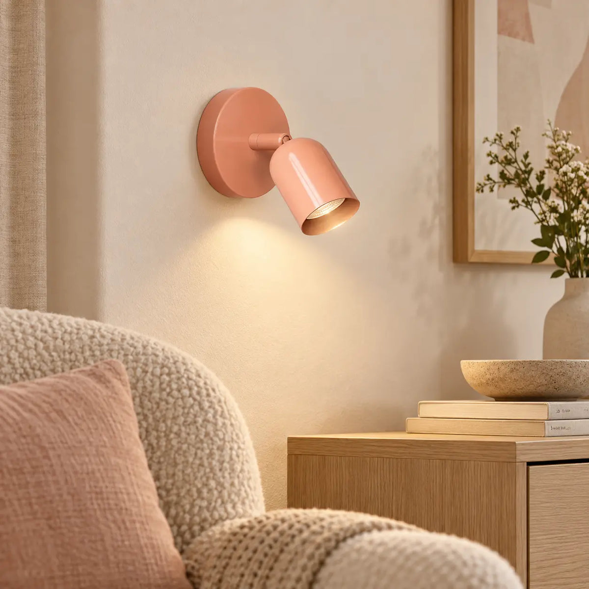 Applique murale orientable rose dans un coin lecture élégant