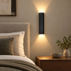 Applique murale LED noire avec éclairage haut et bas dans une chambre